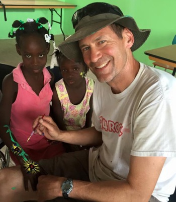 Pastor Bill painting a haitian girls arm
